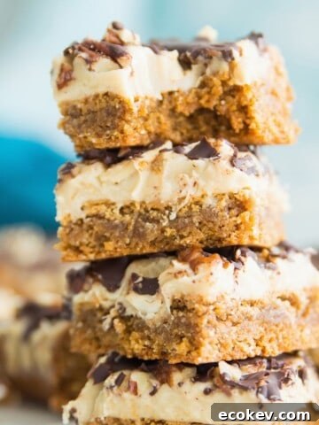 A stack of four turtle cookie bars and the top one has a bite out of it.