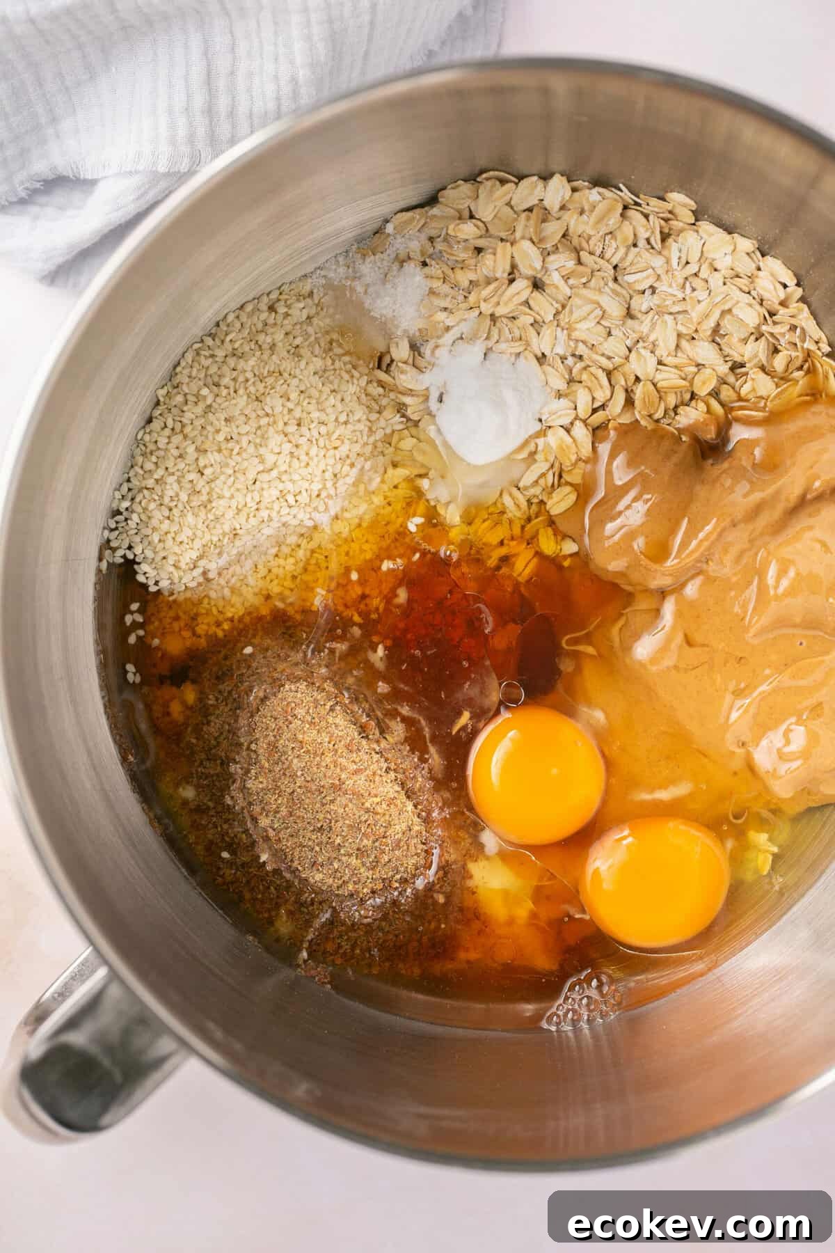 A bowl filled with eggs, oats, flour, coconut oil and maple syrup.