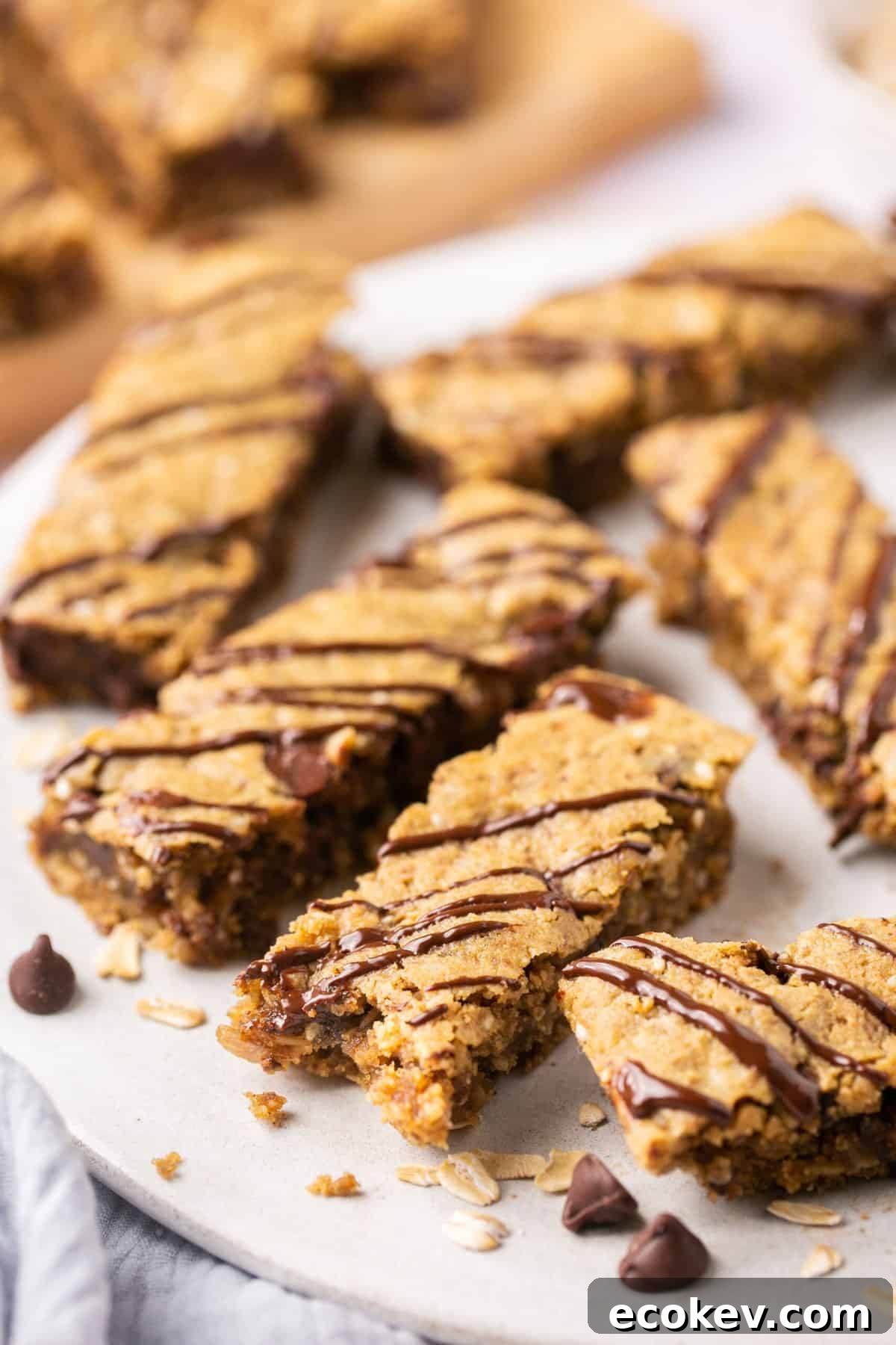 A plate of lactation bars drizzled in chocolate with a bite out of one of them.