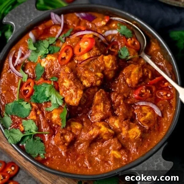 chicken madras in a serving bowl topped with chilles and coriander