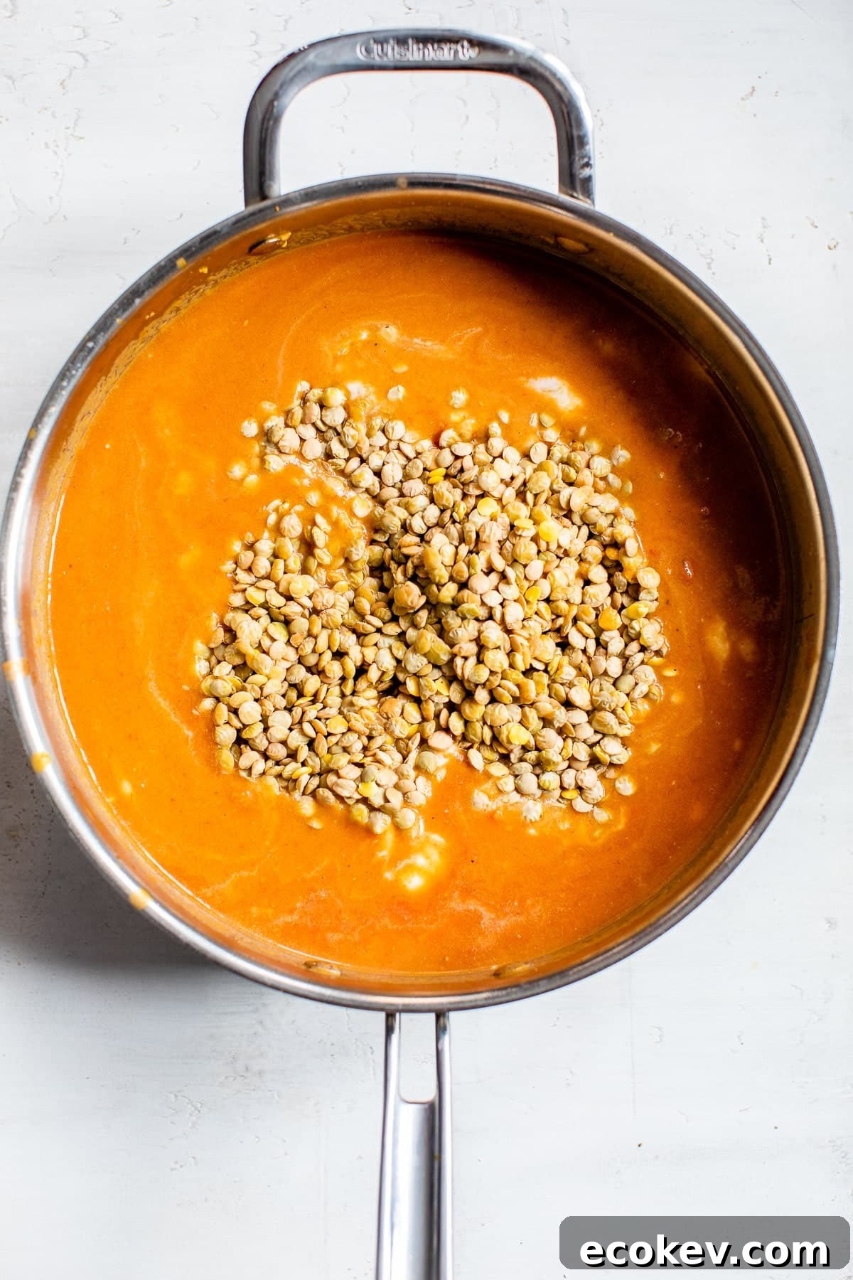 lentils in a skillet with an orange-colored sauce