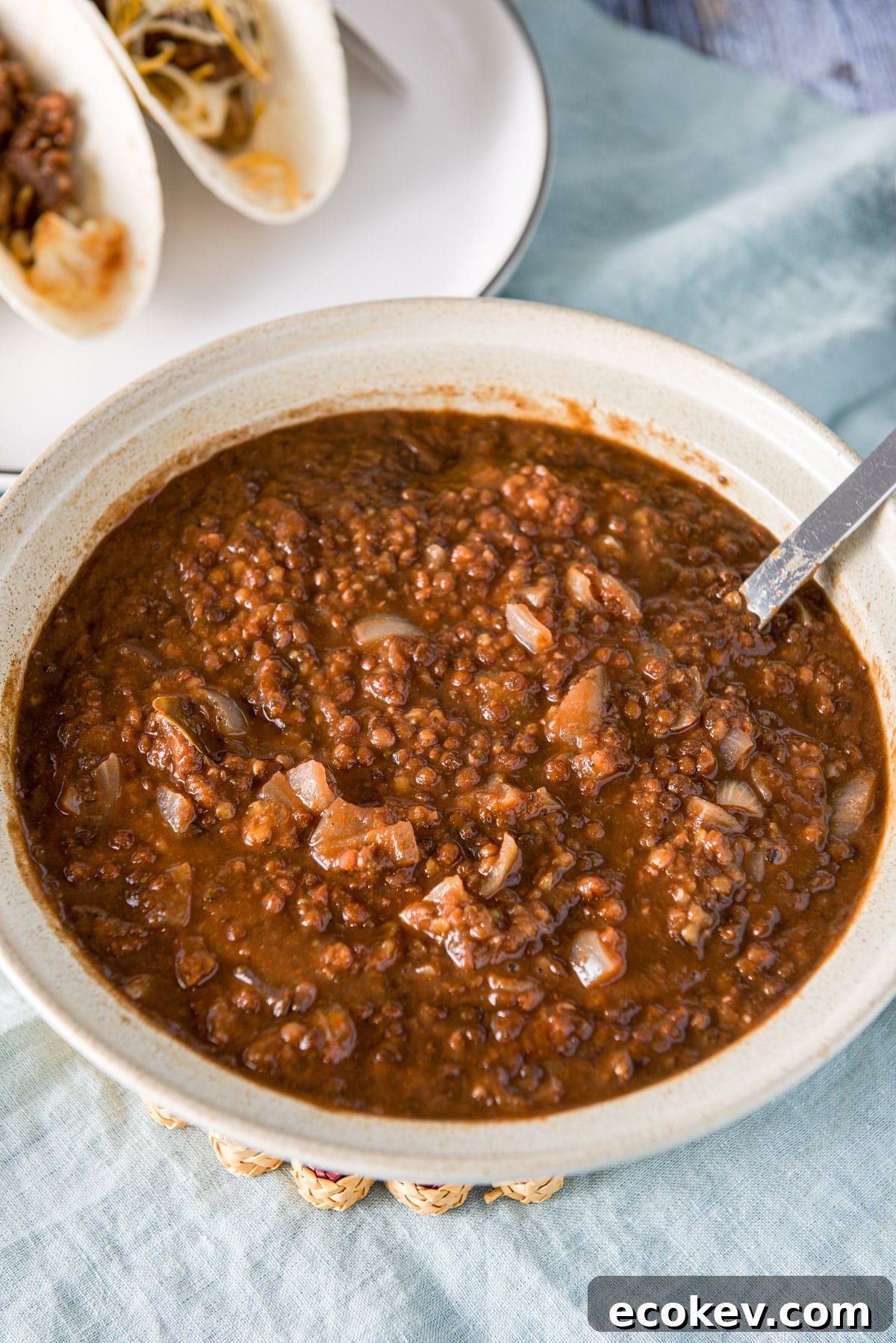 A big bowl filled with lentils with the tacos off to the side