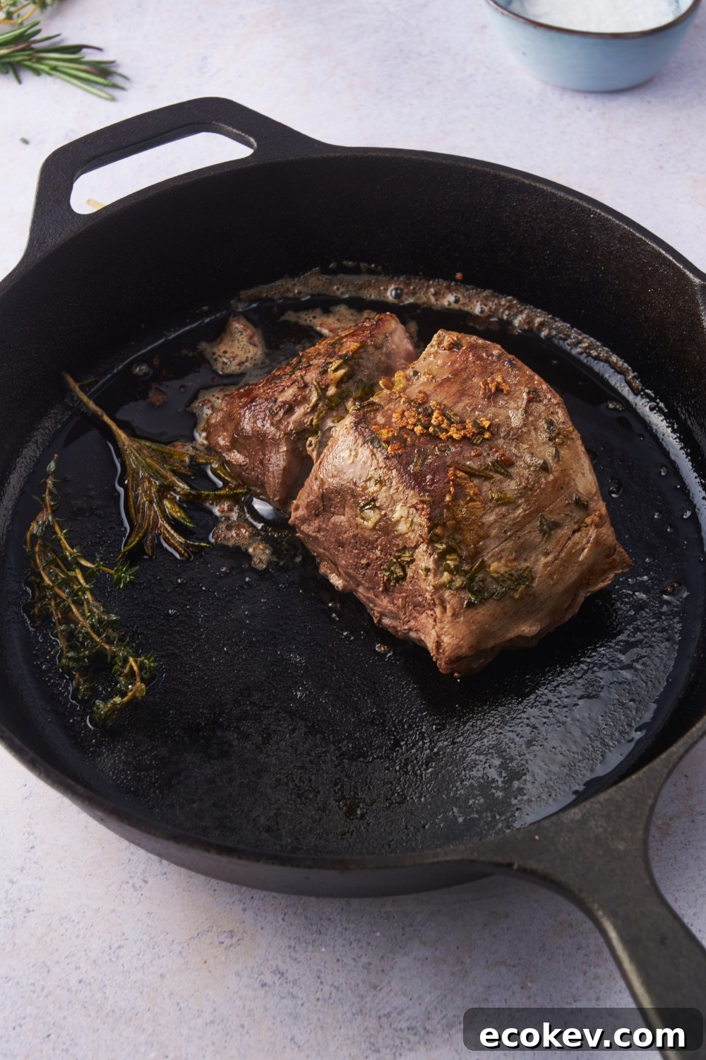 Pan-seared beef tenderloin in a cast iron skillet.