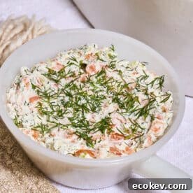 White bowl filled with loxed spread and dill garnish.