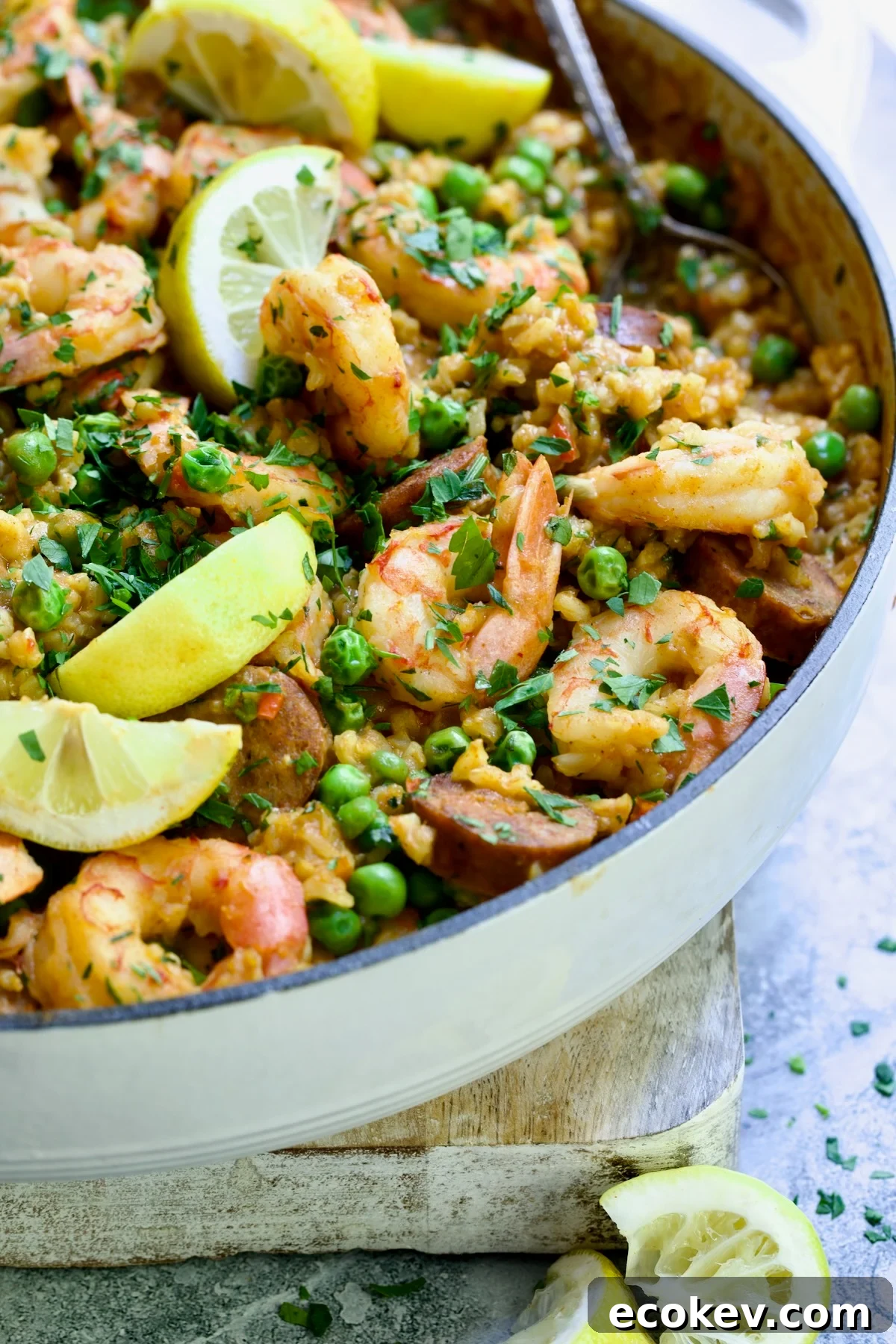 Brown Rice Paella with Shrimp and Chorizo with lemon wedges.