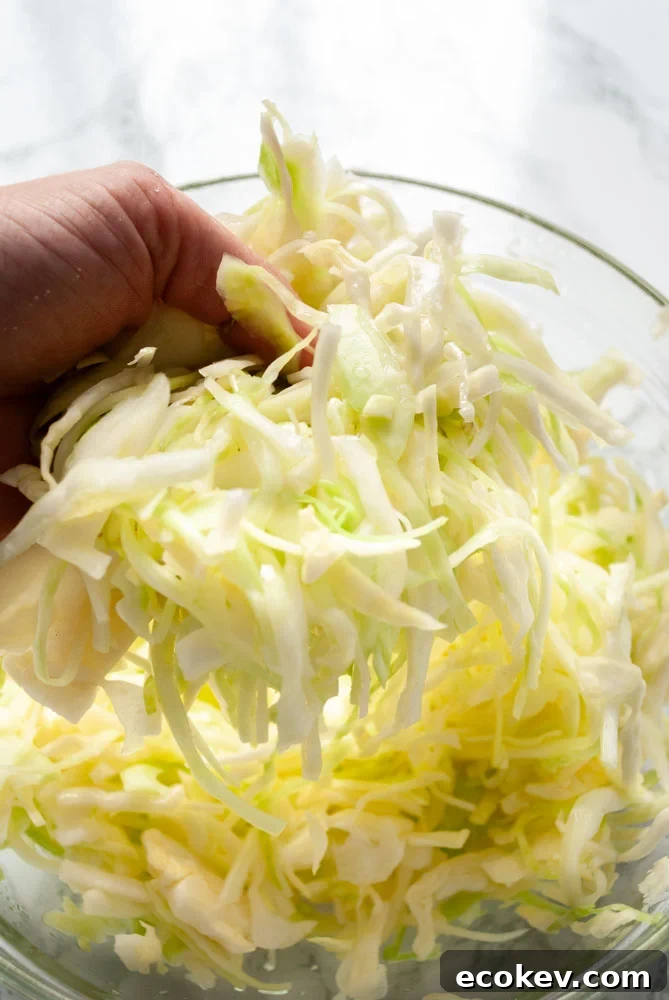 Massaging salt into cabbage in a bowl.