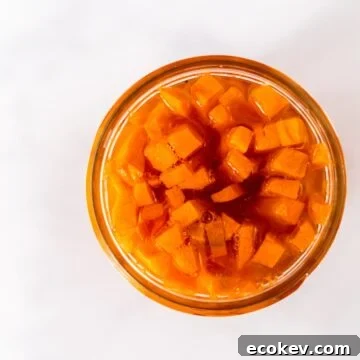 A side view of a mason jar filled with quick pickled carrots.