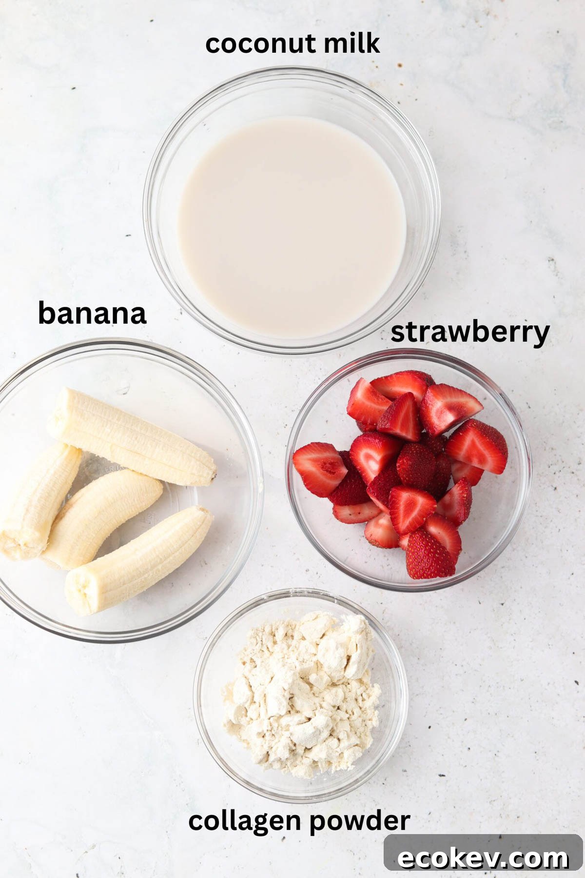 Strawberry banana smoothie bowl ingredients in small glass bowls. 