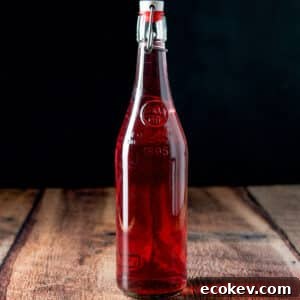 A wooden table with a bottle of raspberry vodka