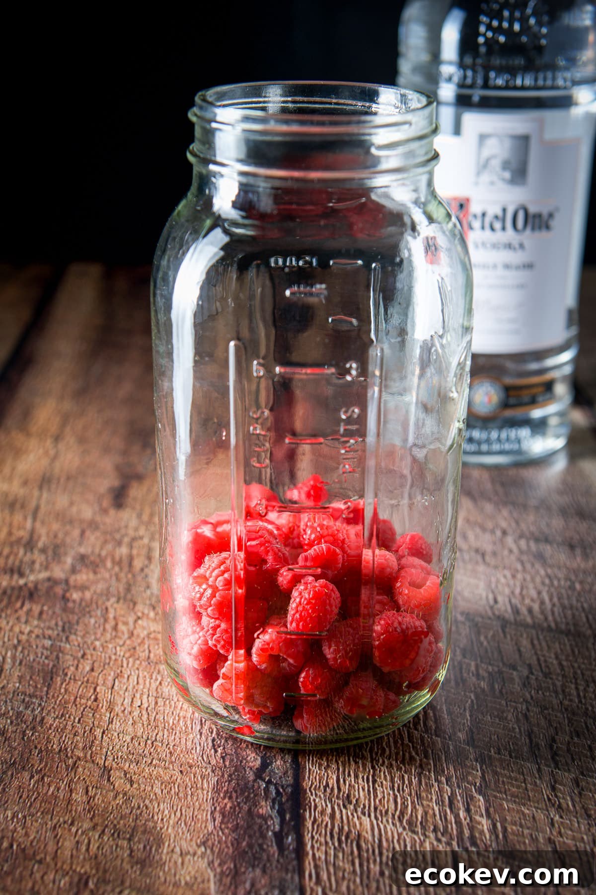 Raspberries in a large jar with the vodka in the back