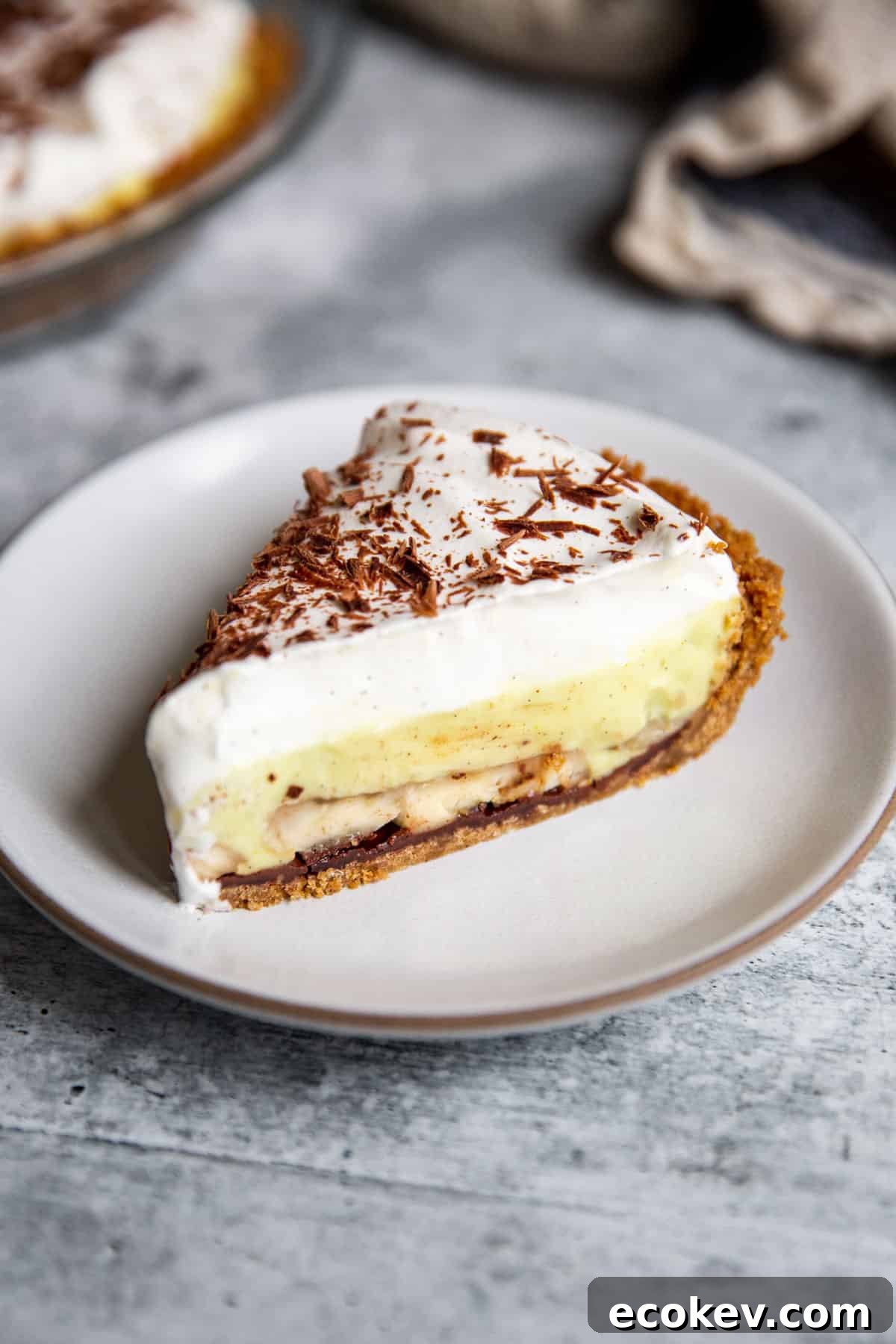 a slice of vegan banana cream pie on a white plate