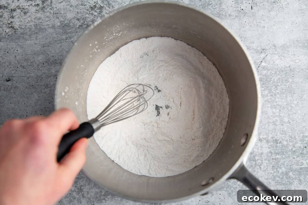 whisking dry ingredients in a metal mixing bowl