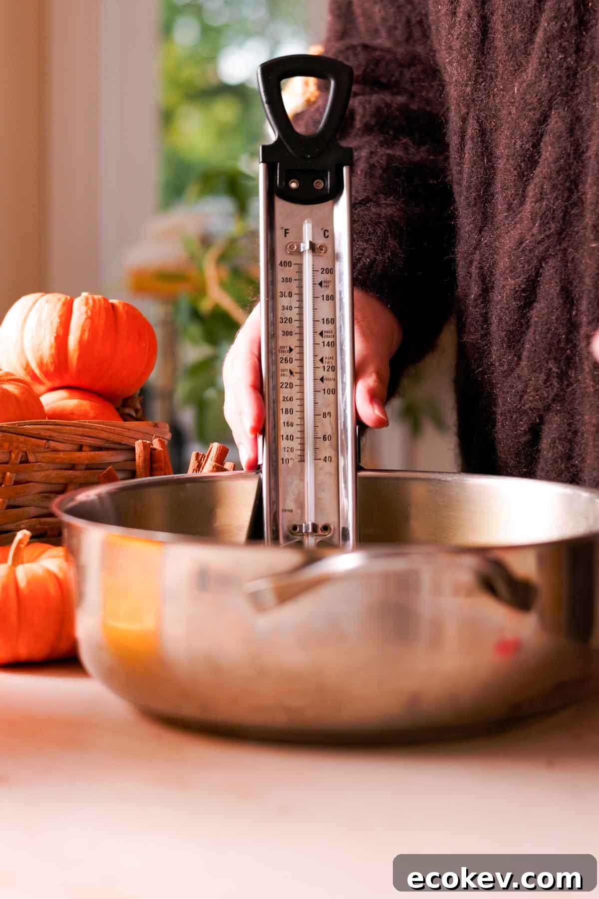 placing metal candy thermometer in a metal pot full of oil