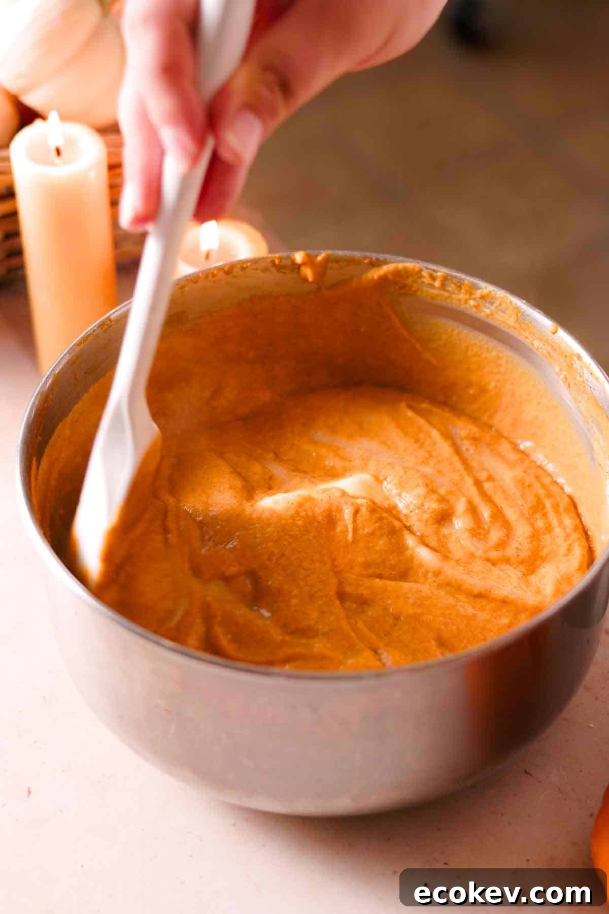 stirring butter into a saucepan filled with hot pumpkin custard as it melts
