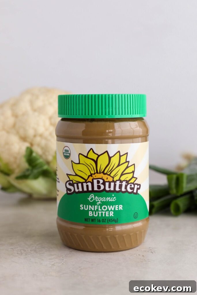Organic SunButter with head of cauliflower and green onion behind the jar by Flora & Vino