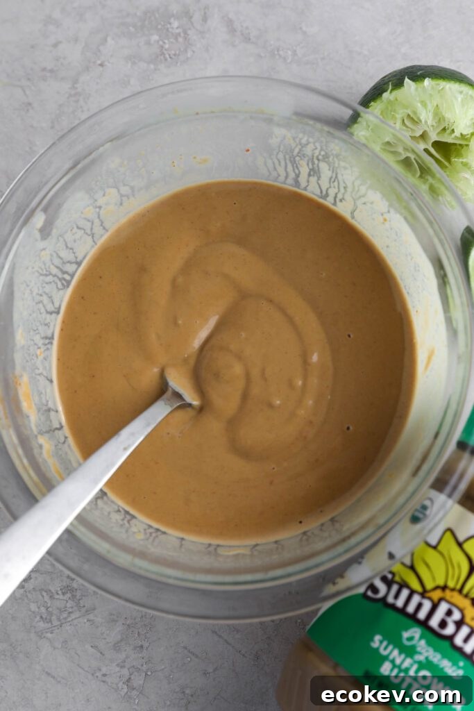SunButter sauce mixed in glass bowl with fork with limes and SunButter on the side by Flora & Vino