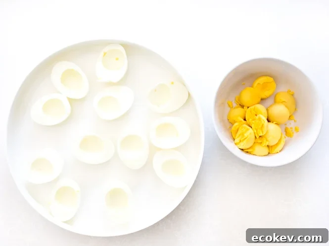 scooping egg yolks out of eggs