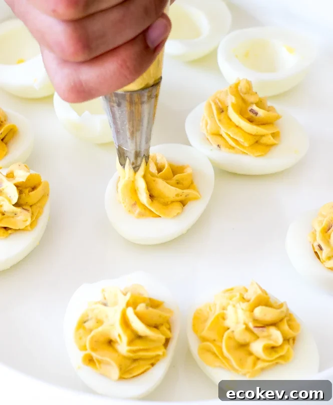 Piping deviled eggs on plate