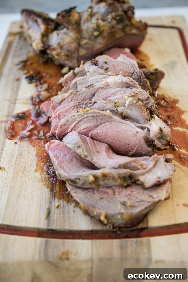 oven roasted boneless leg of lamb resting on a cutting board