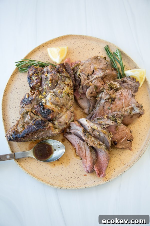medium rare oven roasted boneless leg of lamb sliced on a platter