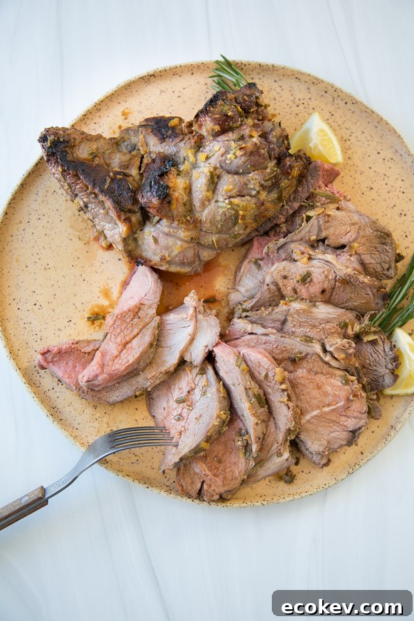 slow roasted leg of lamb sliced on a platter with fork