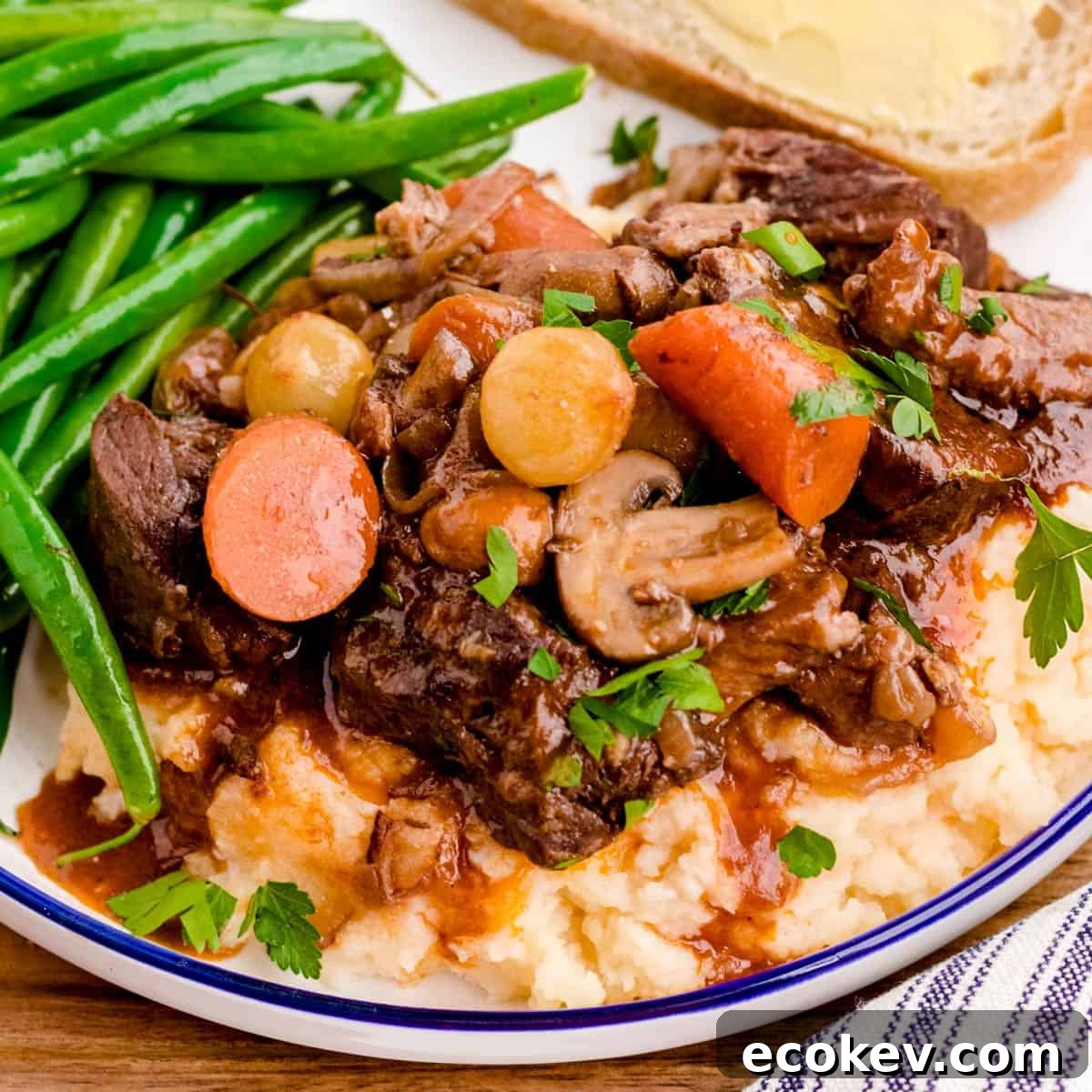 A plate of beef bourguignon over mashed potatoes.