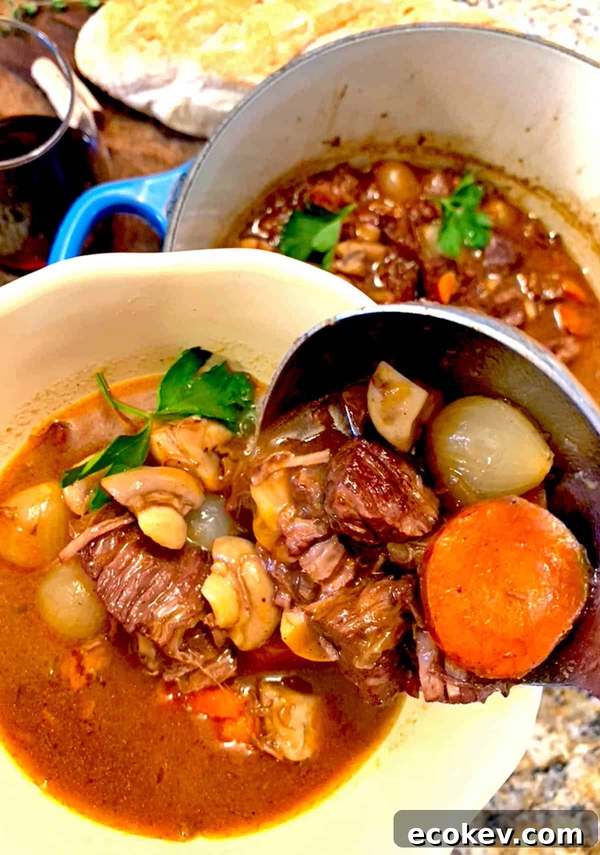 A ladle of beef stew being served in a bowl.