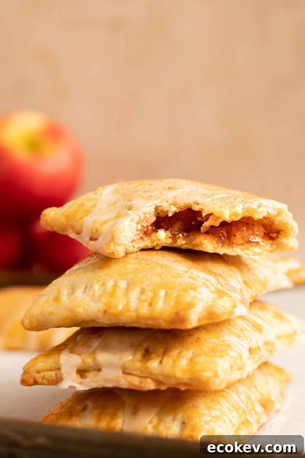 a stack of cinnamon apple pop tars with red apples in the background