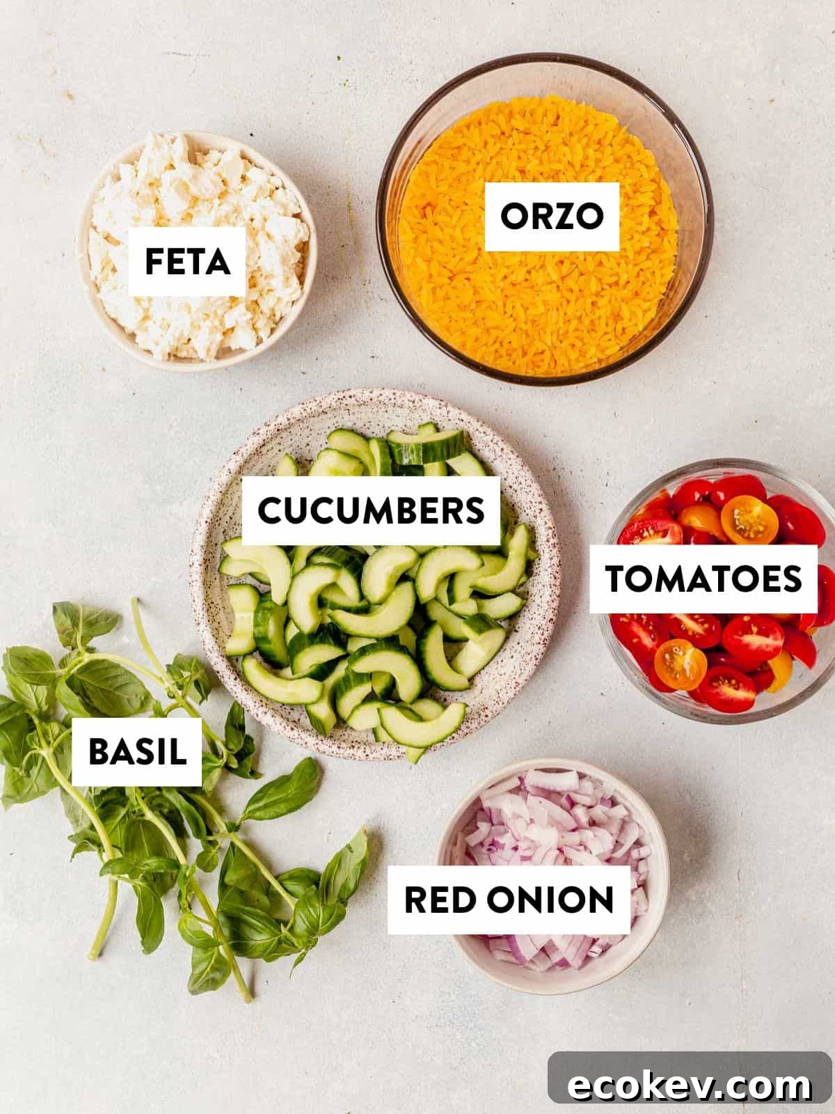 ingredients for salad portion of lemon basil orzo salad laid out on a counter and labeled