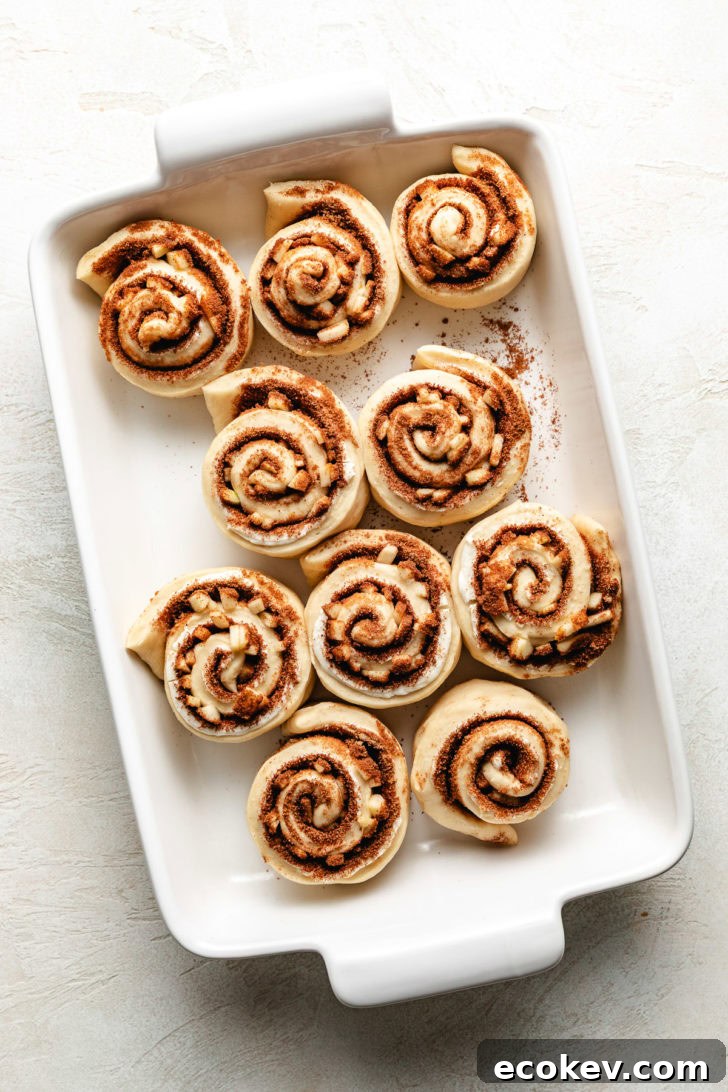 Unbaked cinnamon rolls in a pan.