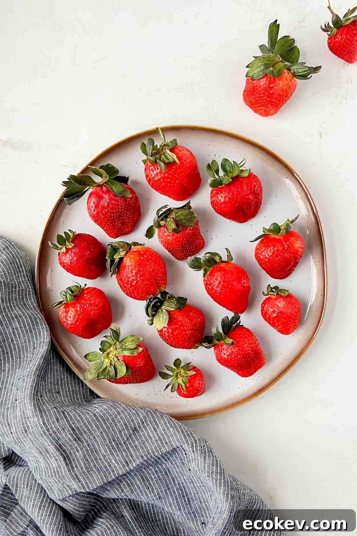 champagne soaked strawberries aligned on white plate.