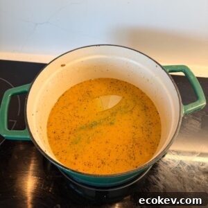 Broth for chicken and dumplings in a pot on the stove.