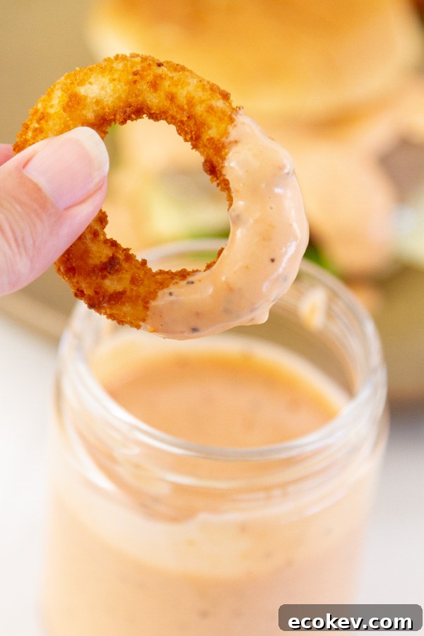 dipping an onion ring into sauce