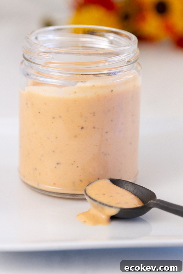 a mason jar with sauce, a spoon has been dipped into the sauce.