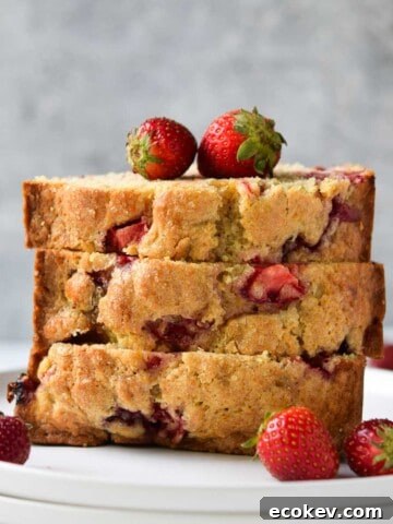 Strawberry buttermilk bread, sliced and stacked on a white plate.