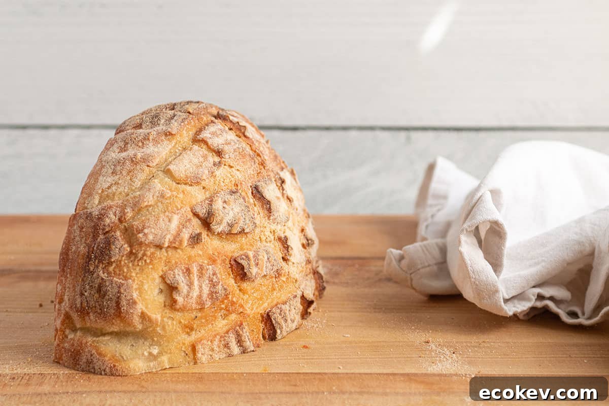 A loaf of sourdough bread cut in half face down on a cutting board. 