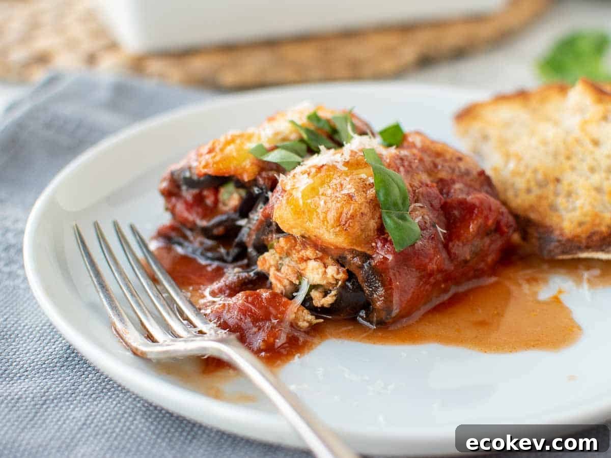 Eggplant Rollatini rolled and filled and topped with tomato sauce and cheese.