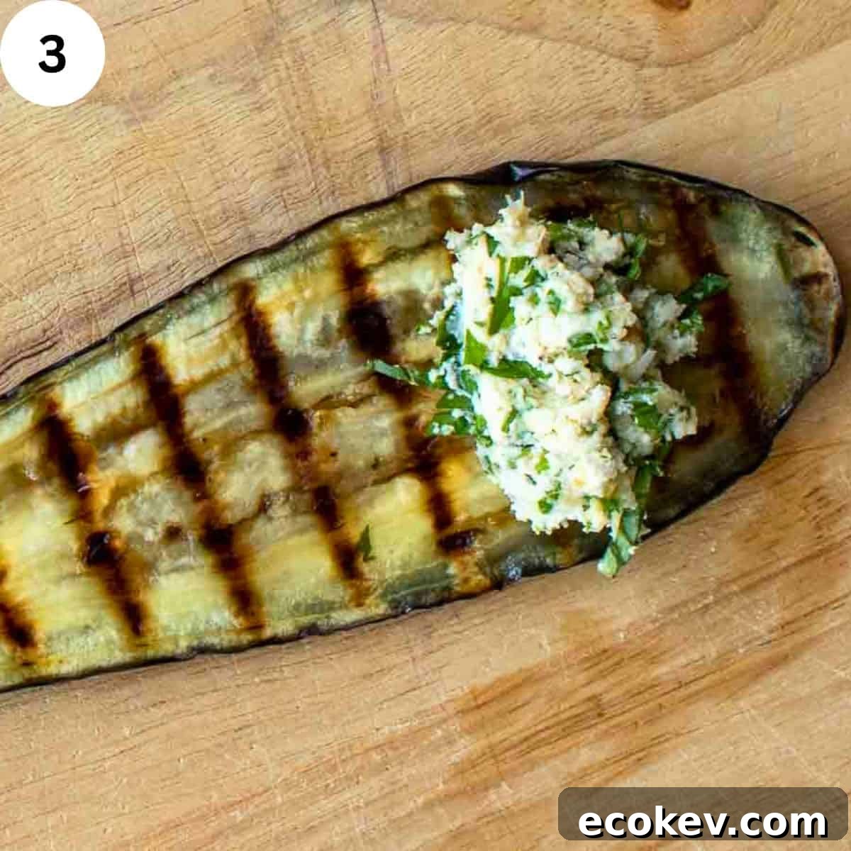 A spoonful of ricotta cheese filling on a grilled slice of eggplant.