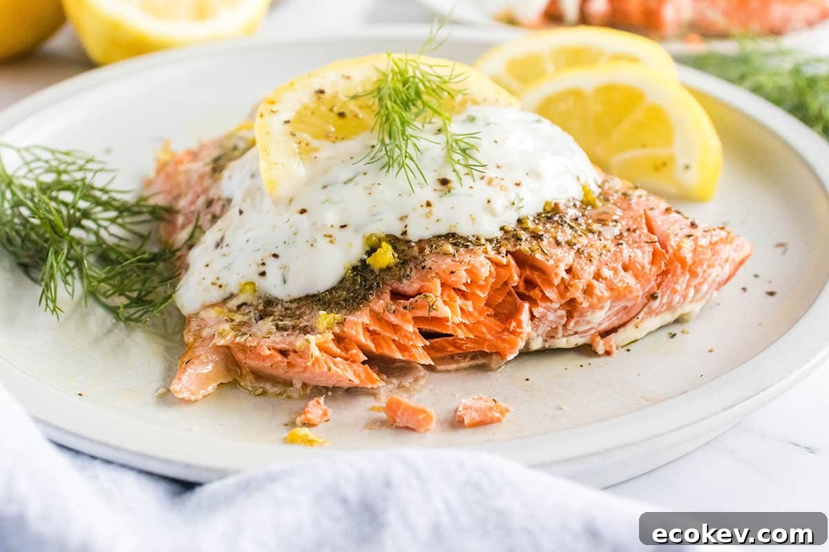 Lemon dill sauce on top of a baked salmon fillet.