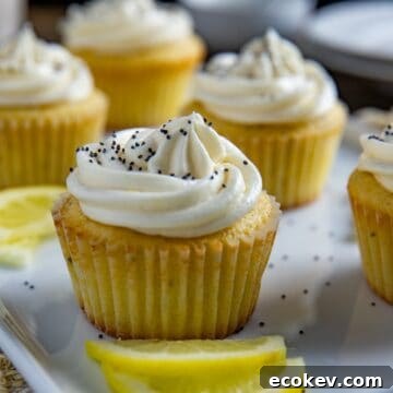 Frosted cupcakes on light blue serving platter with lemon slices as garnish.
