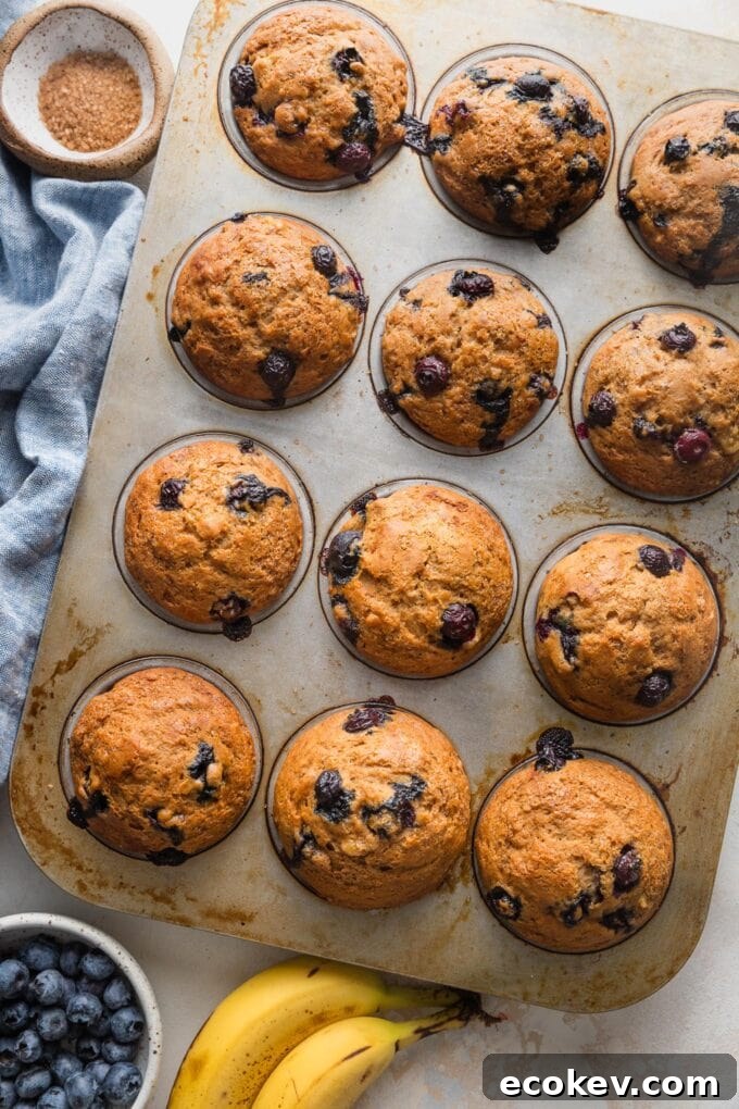 Just-baked banana blueberry muffins cooling briefly in the pan.