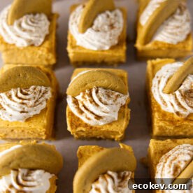 No bake pumpkin cheesecake bars with a gingersnap cookie on top, laid out in a grid.
