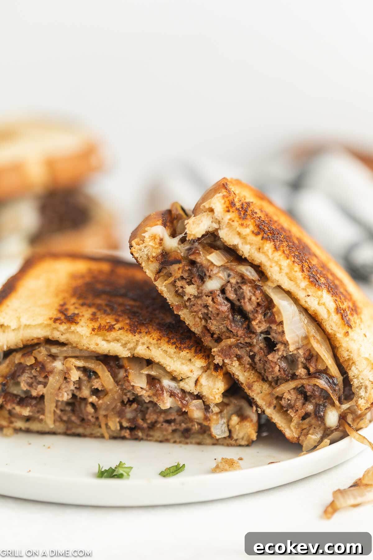 Patty Melt cut in half and stacked on a plate