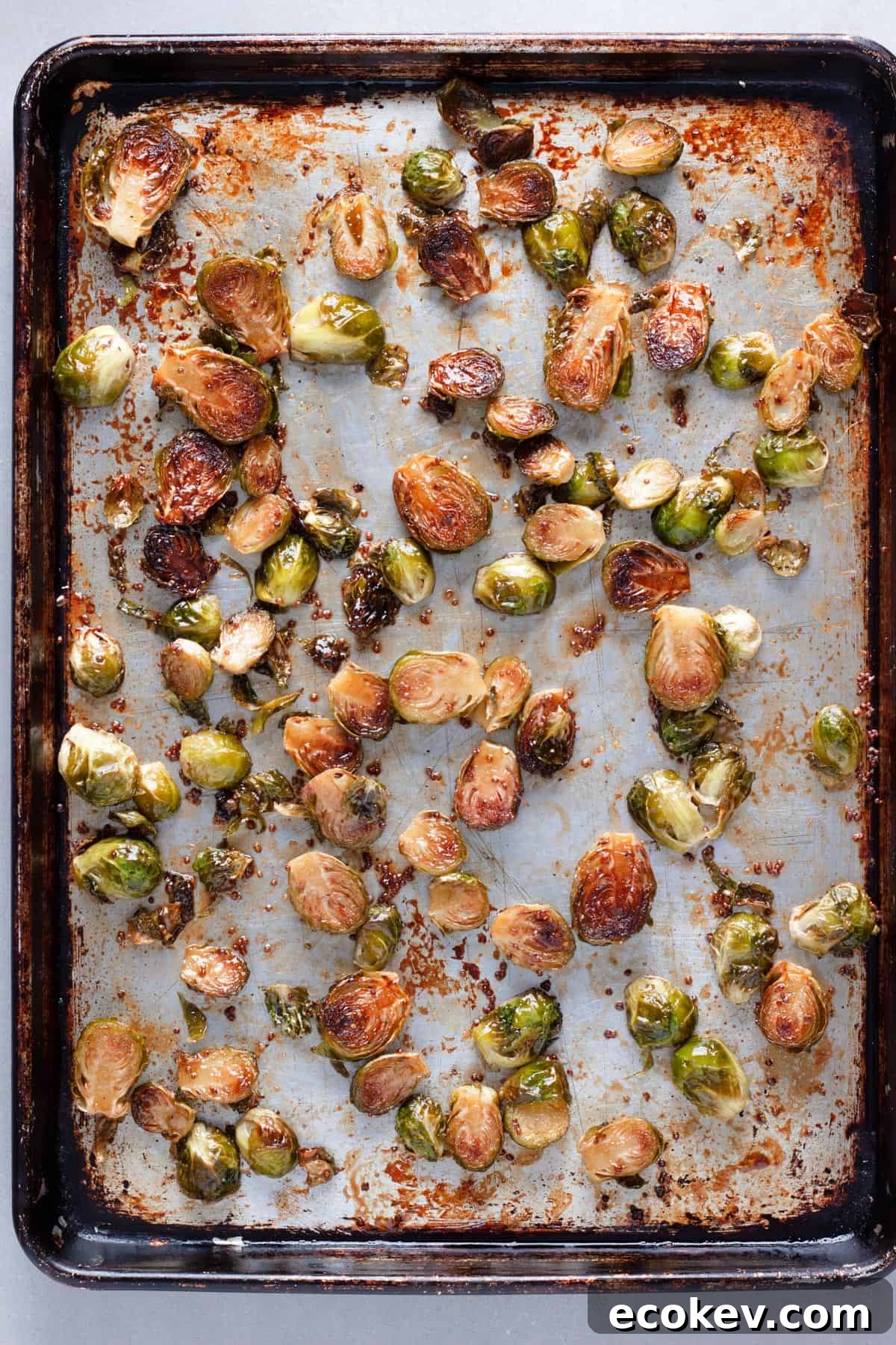Maple balsamic brussels sprouts on a baking sheet roasted to golden brown.