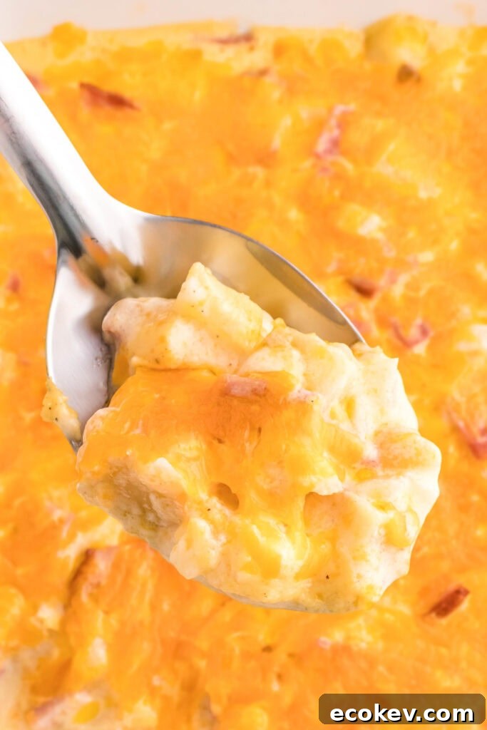 scooping out ham and potato casserole from baking dish