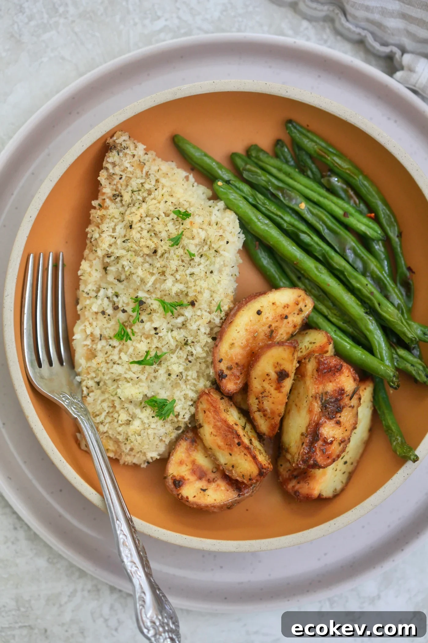 breaded fish on plate with potatoes and green beans