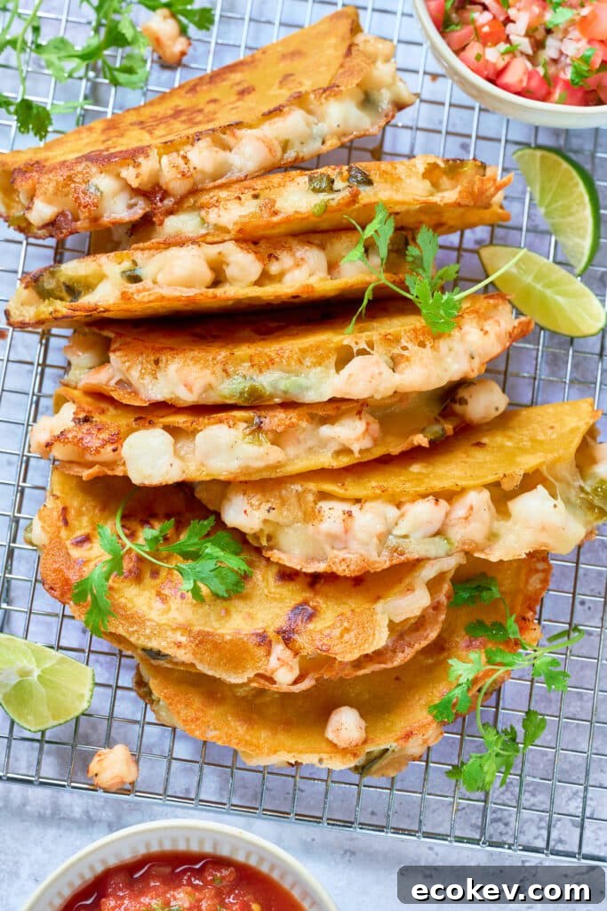 Crispy and cheesy shrimp tacos stacked on a cooling rack.