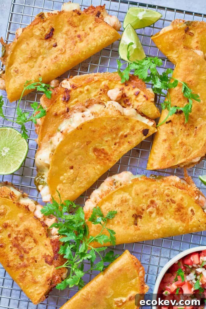 Golden brown crispy tacos on a rack garnished with limes and cilantro