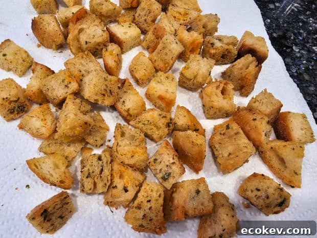 When done air frying, the salad croutons cool on paper towels.