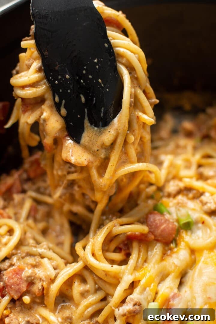 a pair of kitchen tongs serving taco spaghetti
